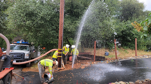 EID Crew Fixing Hit Water Line by Fence Installer - water is shooting up 